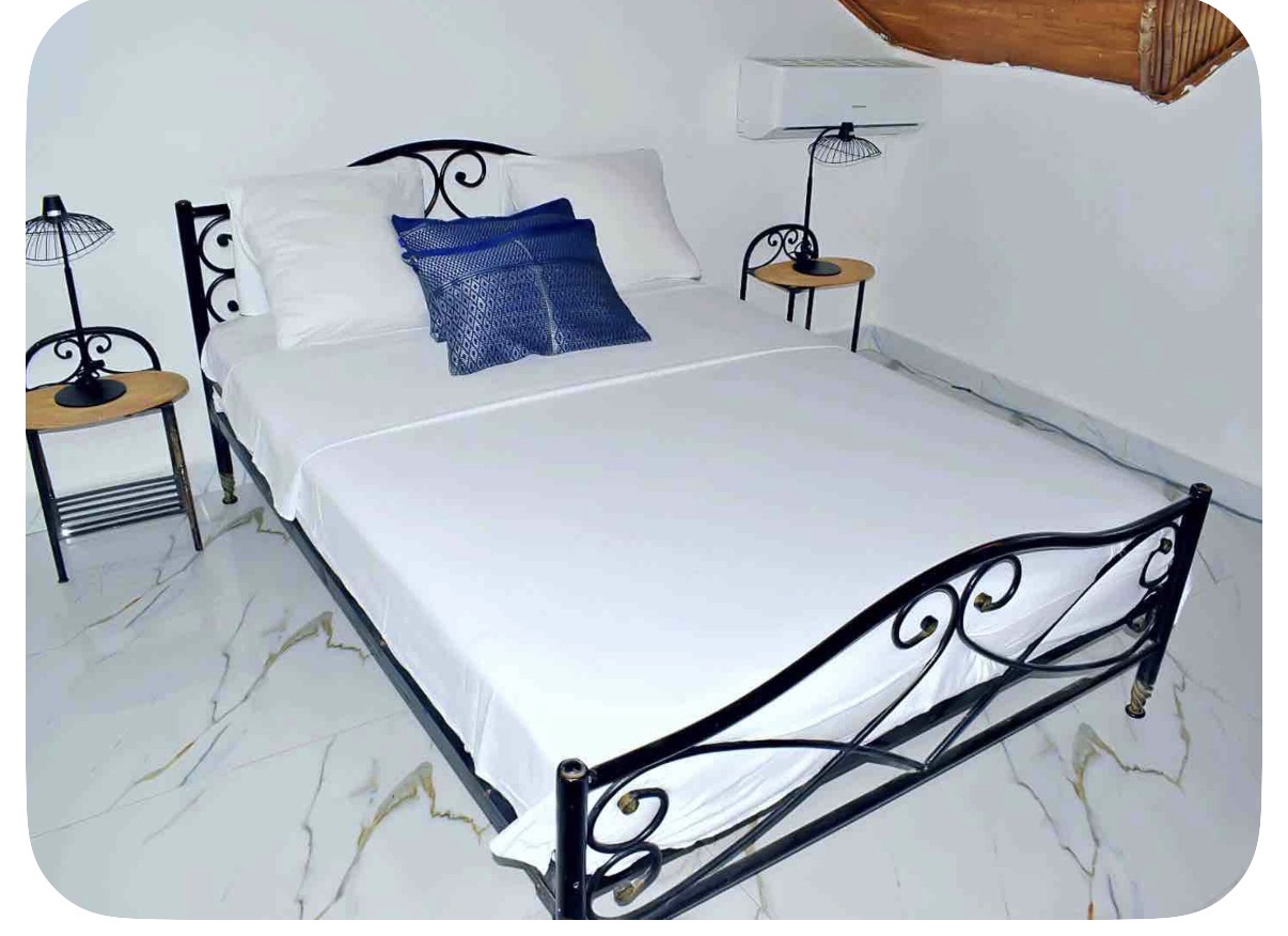 Chambre avec lit double en fer forgé et climatisation